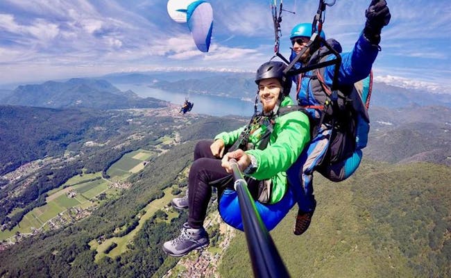 Tandemflug vom Monte Tamaro mit Gleitschirm über Seenlandschaft.