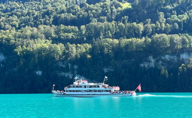 Lake Brienz: Boat on clear water, surrounded by mountains, perfect for boat tours and nature experiences.