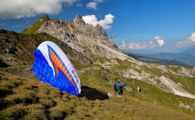 Gleitschirmfliegen in Davos, zwei Piloten heben ab, Berglandschaft.