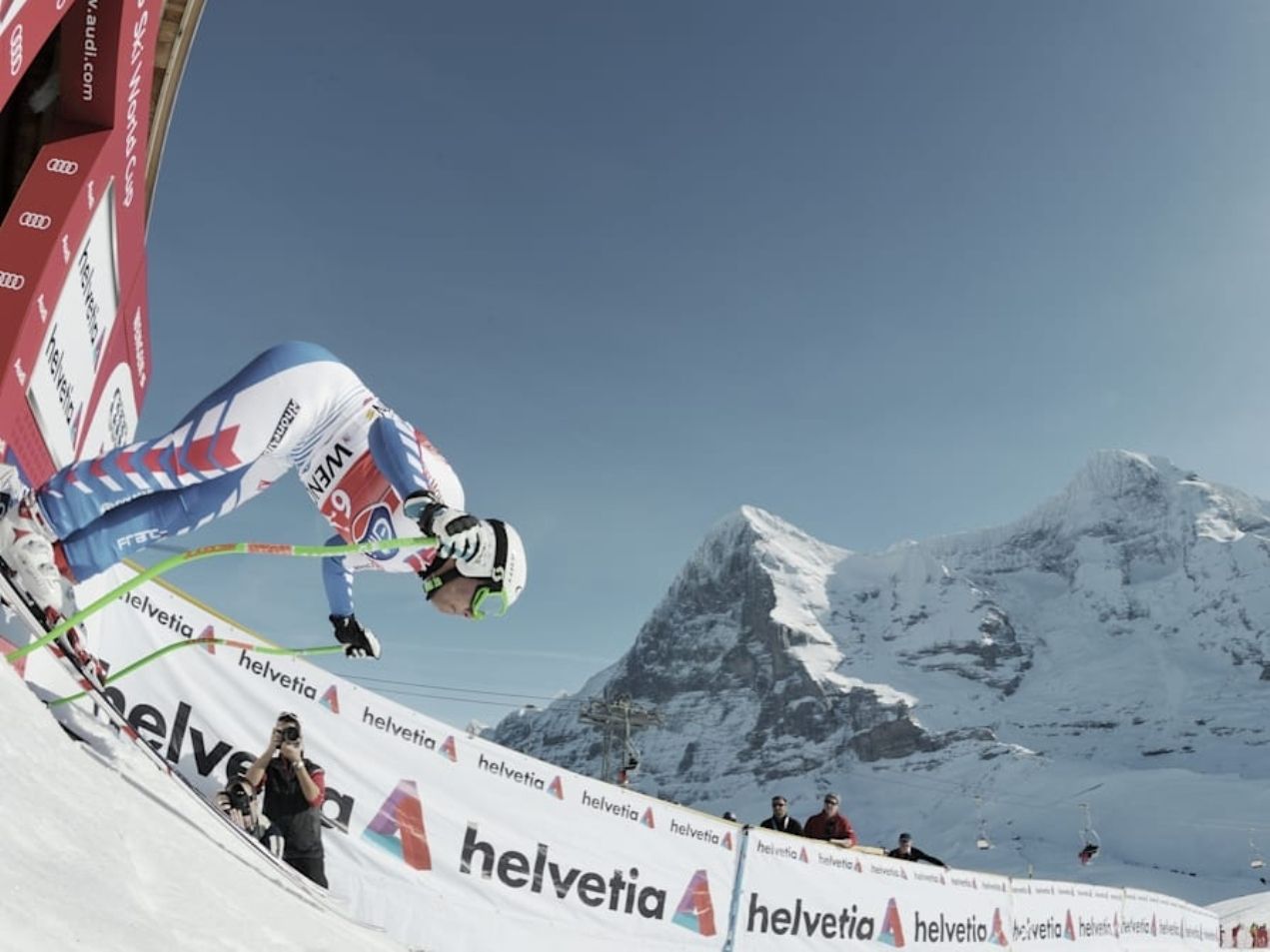 Lomba Lauberhorn Wengen dengan pemain ski bertanding di latar belakang pegunungan.