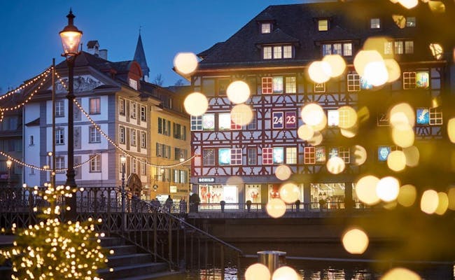 Lucerne pendant la période de Noël avec un éclairage festif et des bâtiments historiques au bord de la rivière.