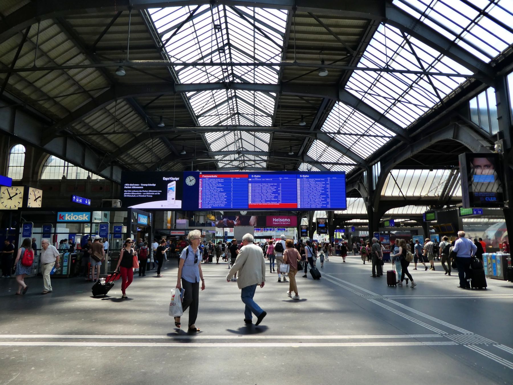 Zürich Banegård med fodgængere og informationsskærme.