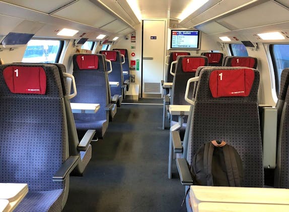 Treininterieur: comfortabele zitplaatsen en tafel in modern design voor reizigers.