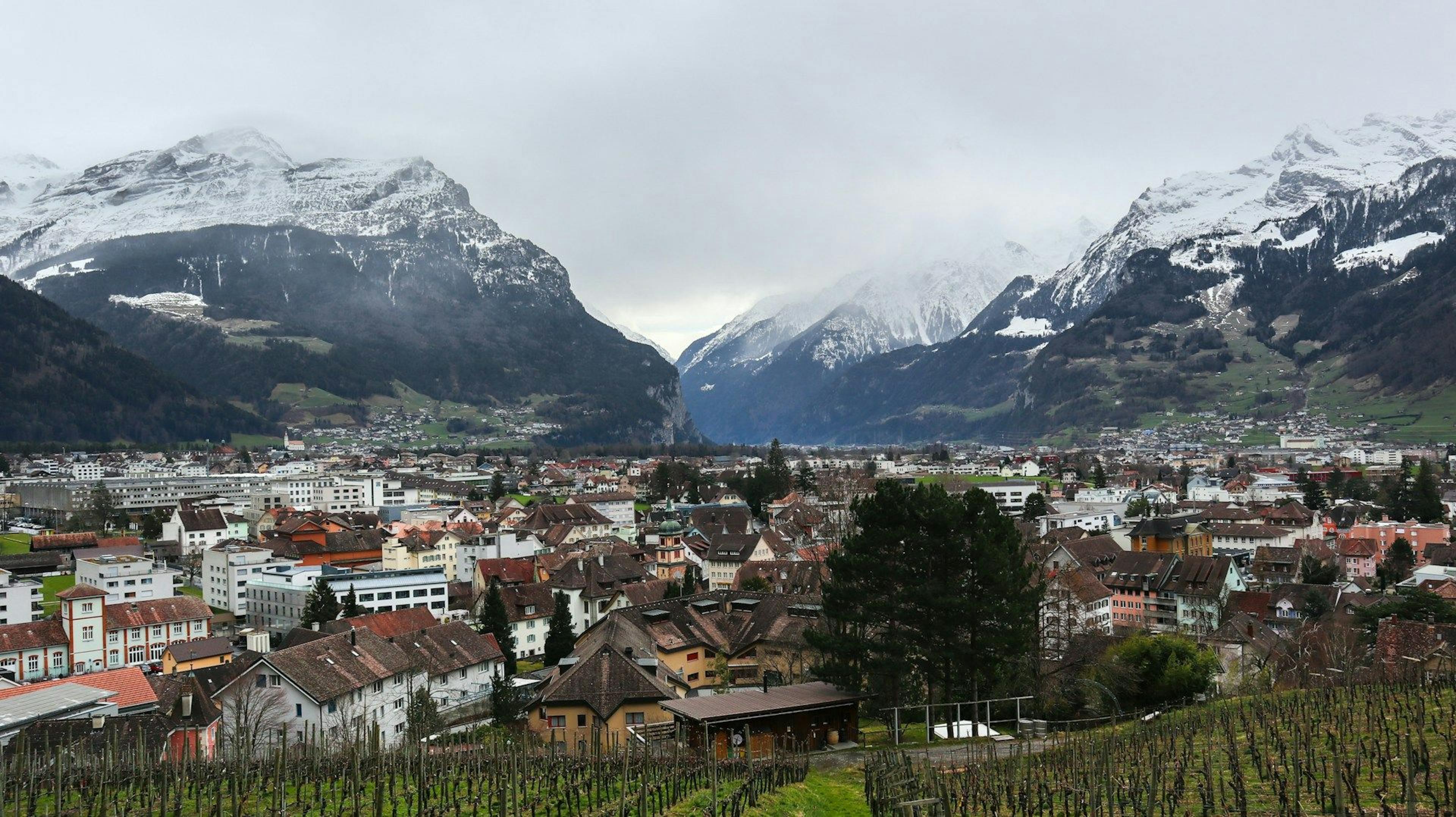 Altdorf: Pemandangan gunung bersalji dan bandar yang idyll ketika musim sejuk dengan banyak rumah dan alam semula jadi.