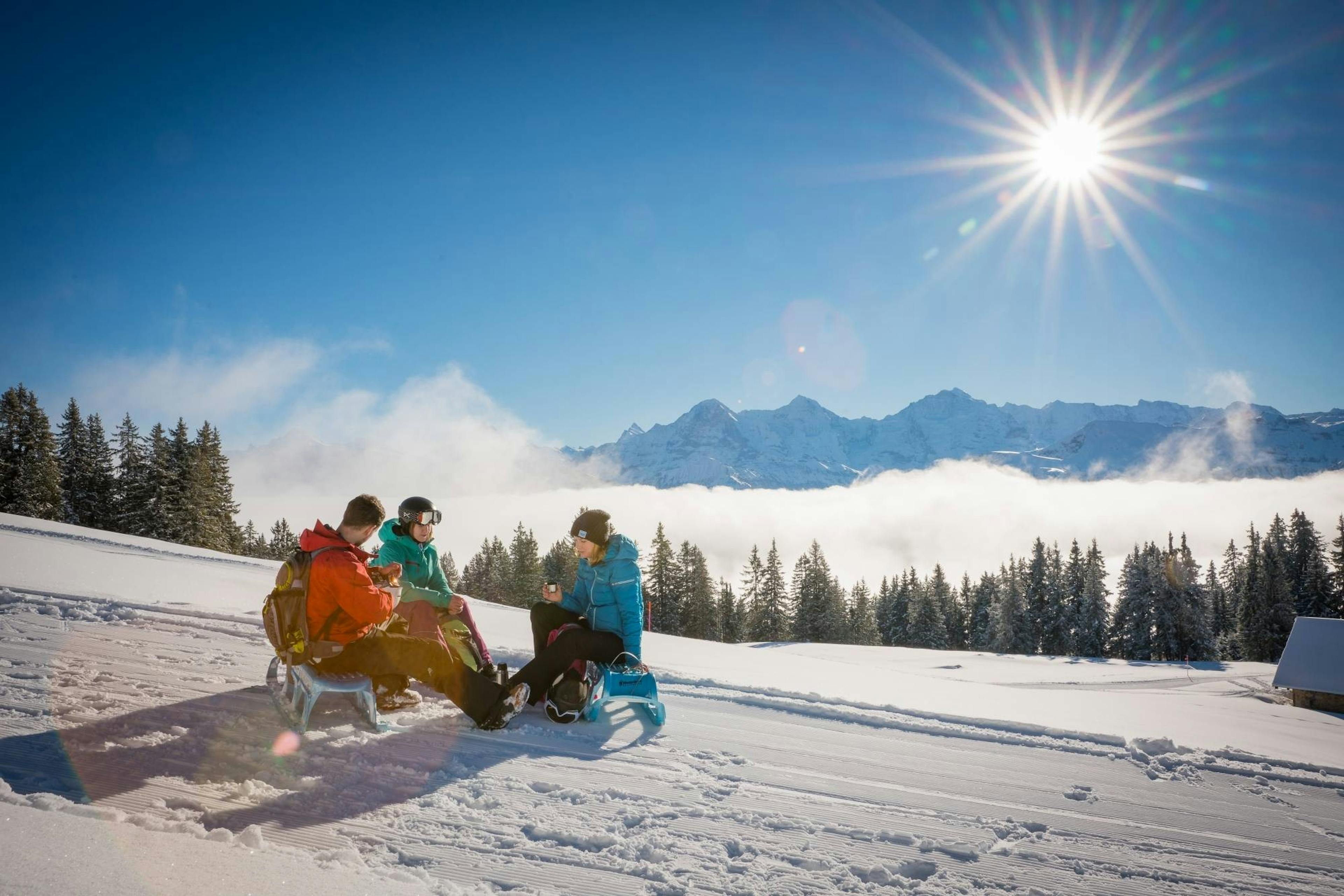 Sledding at Niederhorn with mountains in the background