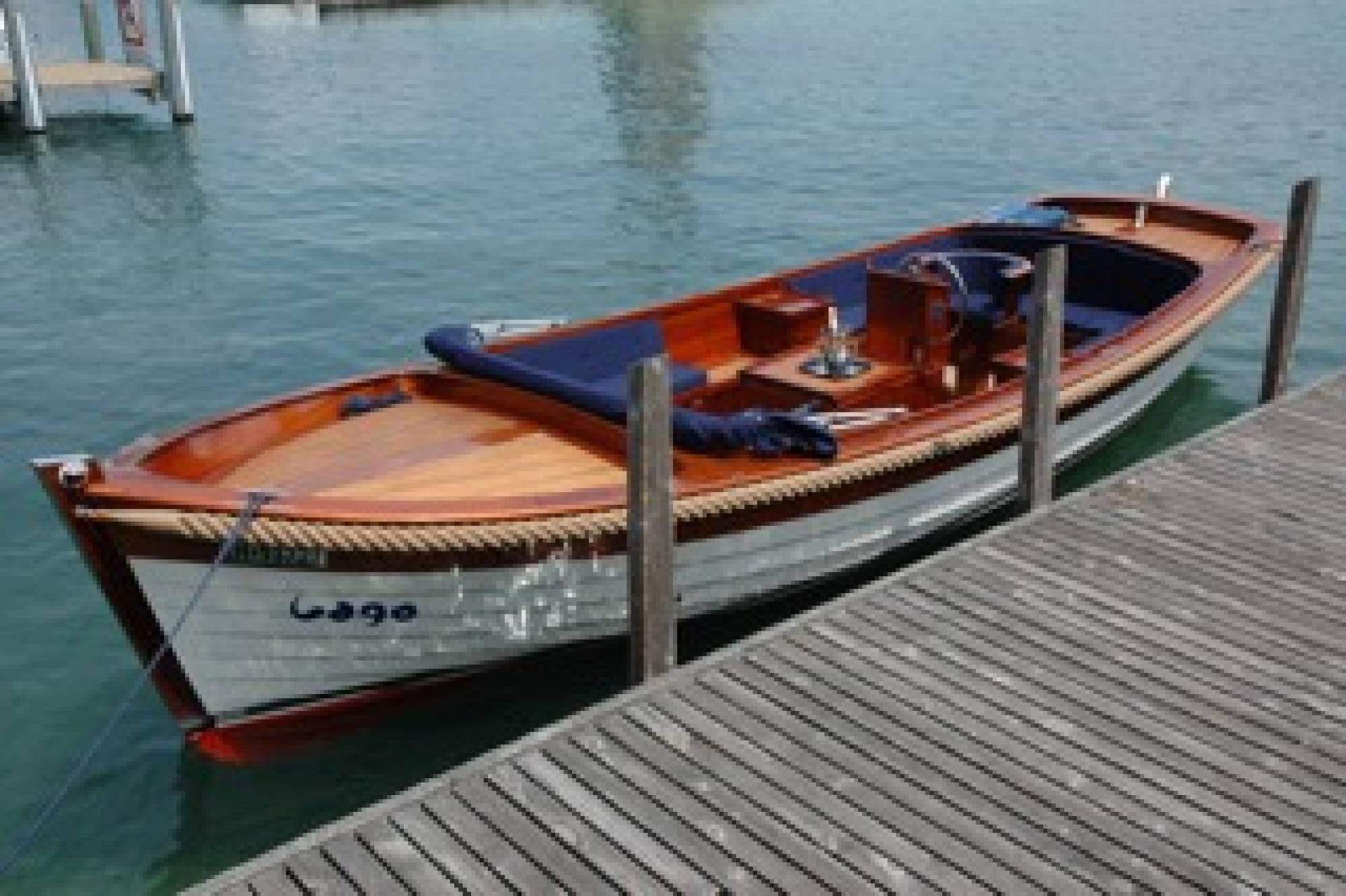 Rybářská loď u mola na klidné vodě ve Švýcarsku