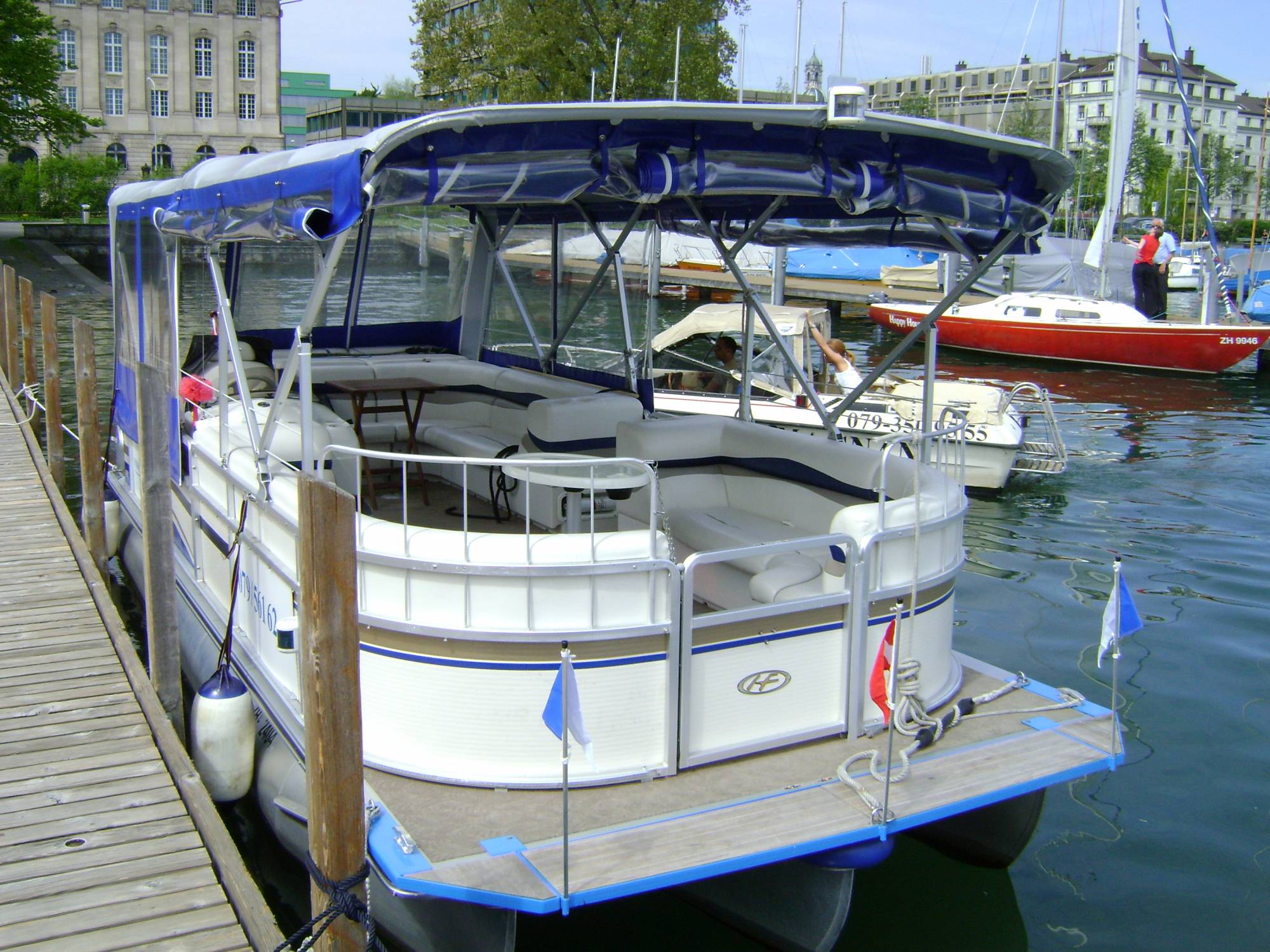 Plavba lodí v Curychu s motorovým člunem v přístavu. Viditelné jsou uvolněné počasí a kotviště.