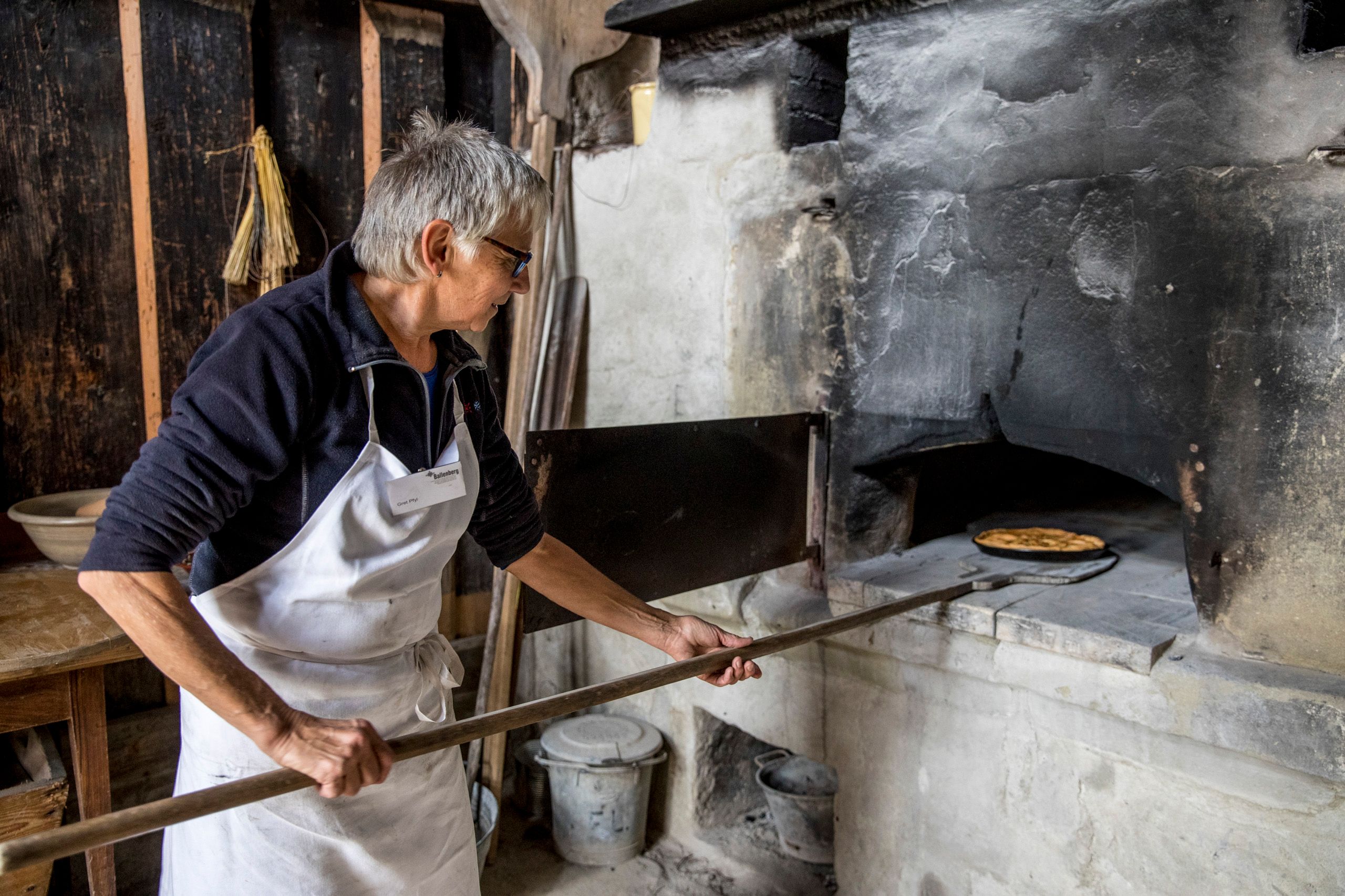 巴伦贝格：女士在历史烤箱中烘焙传统面包，深入了解瑞士文化。