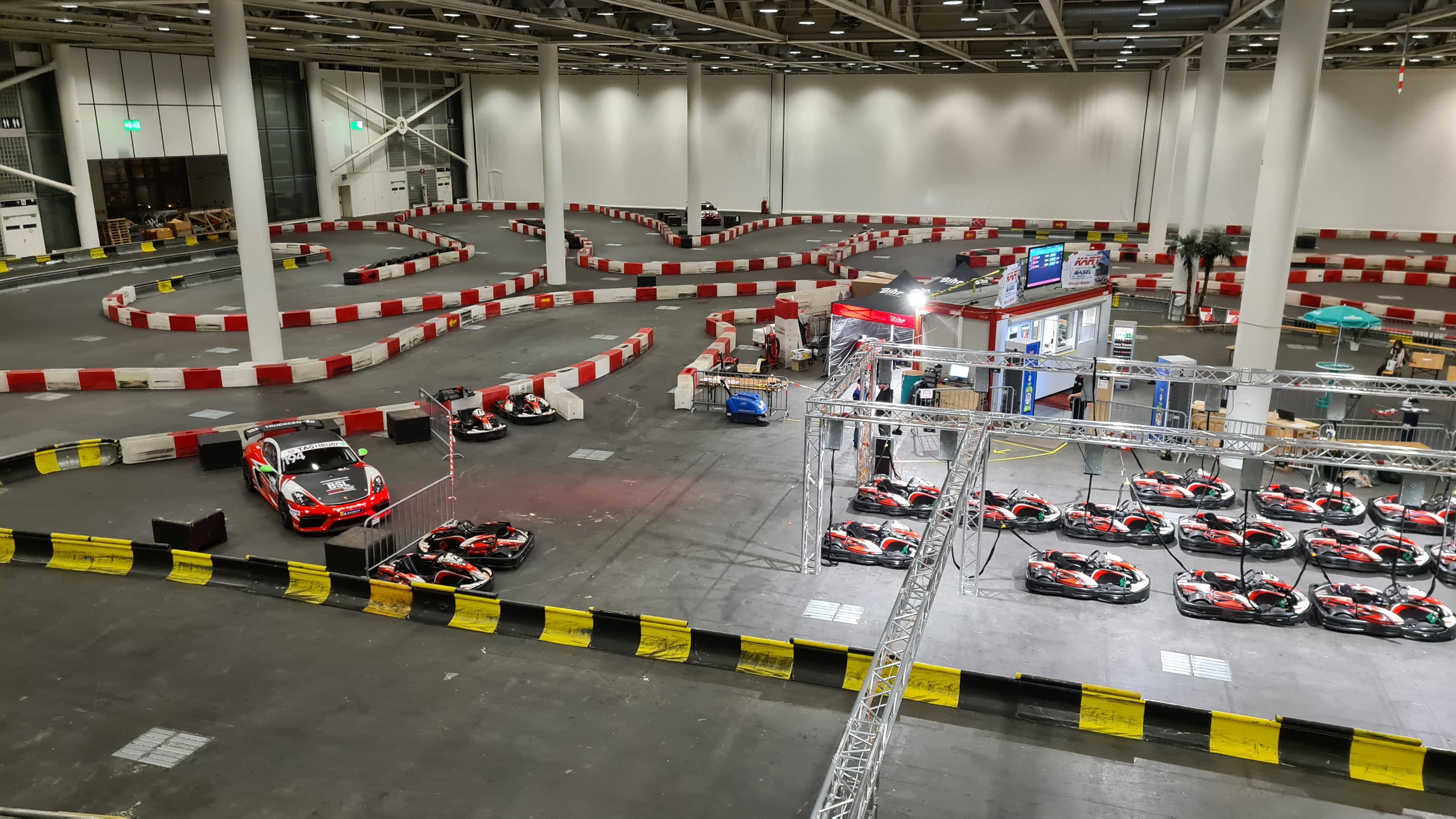Sirkuit gokart: Main balap gokart dalam ruangan di Basel dengan tikungan menantang dan mobil gokart modern.