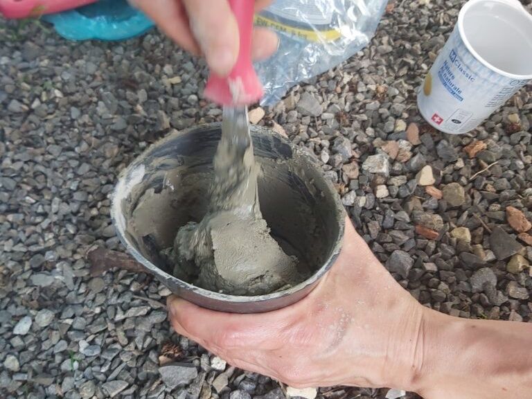 Pouring concrete with a spatula in a bowl on the Rigi
