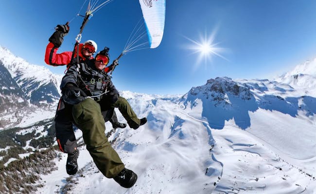 Gleitschirmfliegen in Klosters bei Sonne und Schnee.