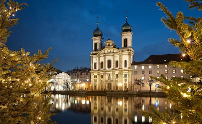 Kapellbrücke à Lucerne la nuit, éclairage de Noël et réflexivité dans l'eau.