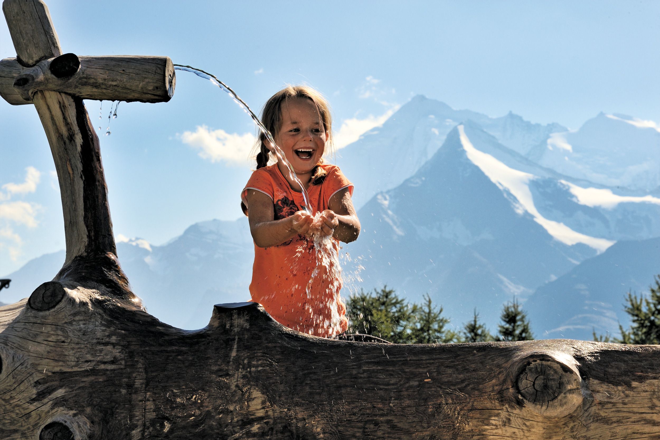 Acqua potabile al pozzo: i bambini godono della natura in Svizzera d'estate.