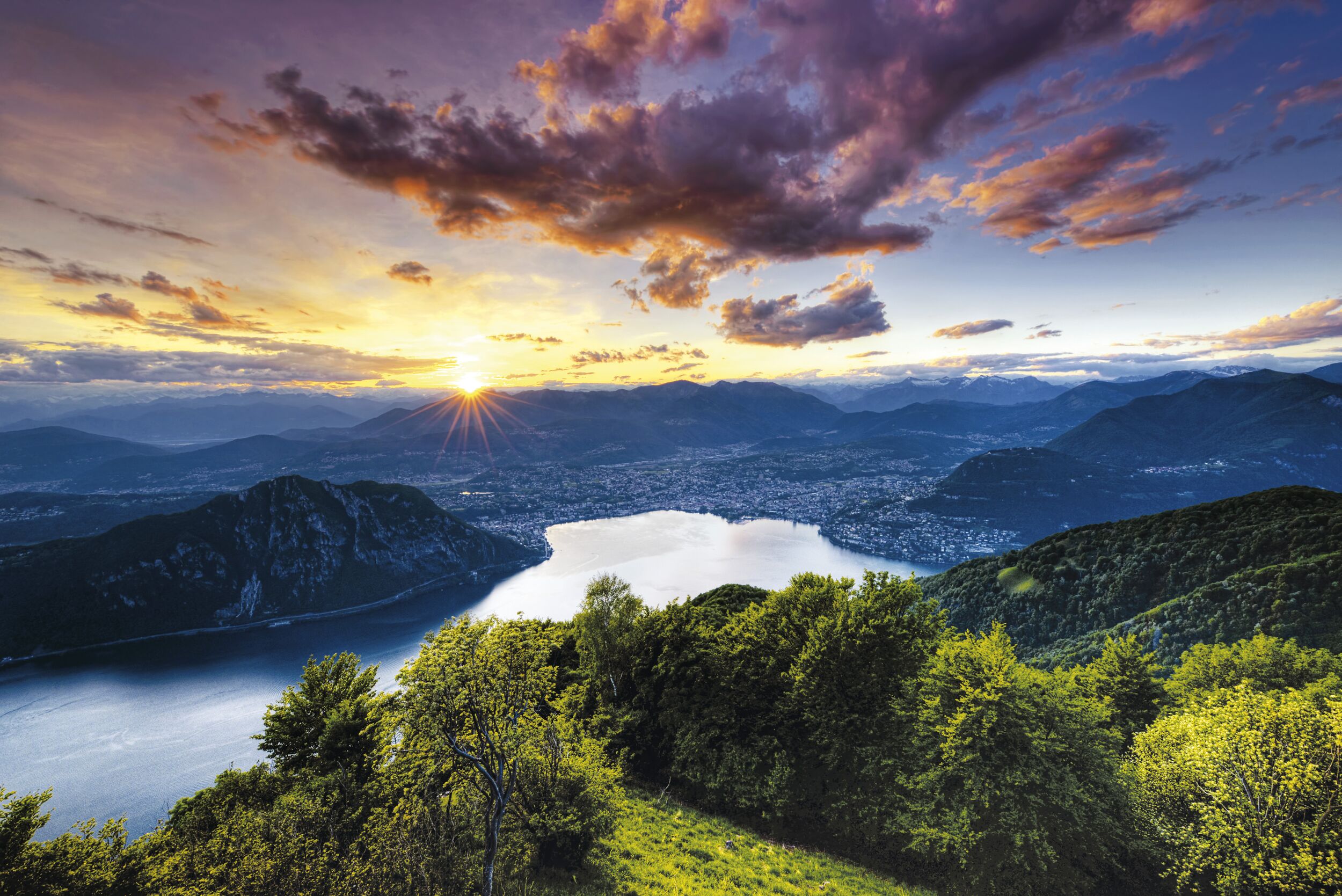 Lago di Lugano con tramonto, montagne e vista sulla città