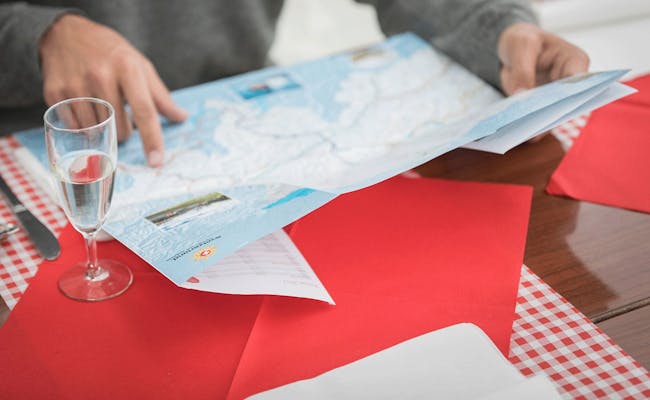 Réseau de transport public en Suisse, personne indiquant sur une carte, nappe rouge et blanche
