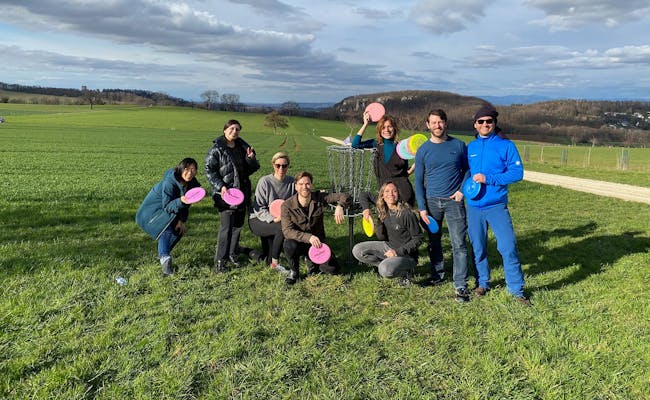 Lila Disc: Gruppo gioca a Disc Golf nella natura con cielo sereno e tempo invernale.