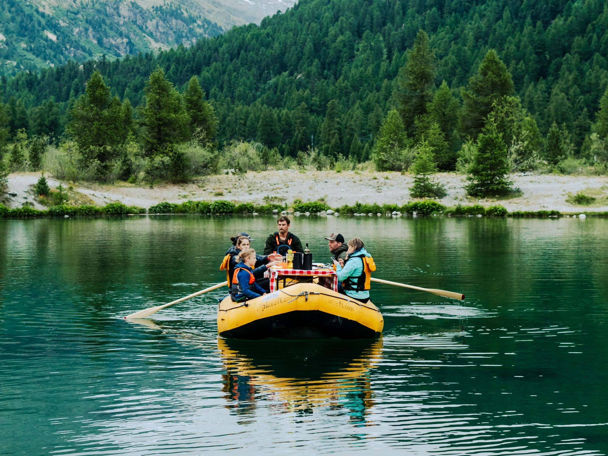 Raclette by the lake with friends in summer - relax, grill, and enjoy in nature.