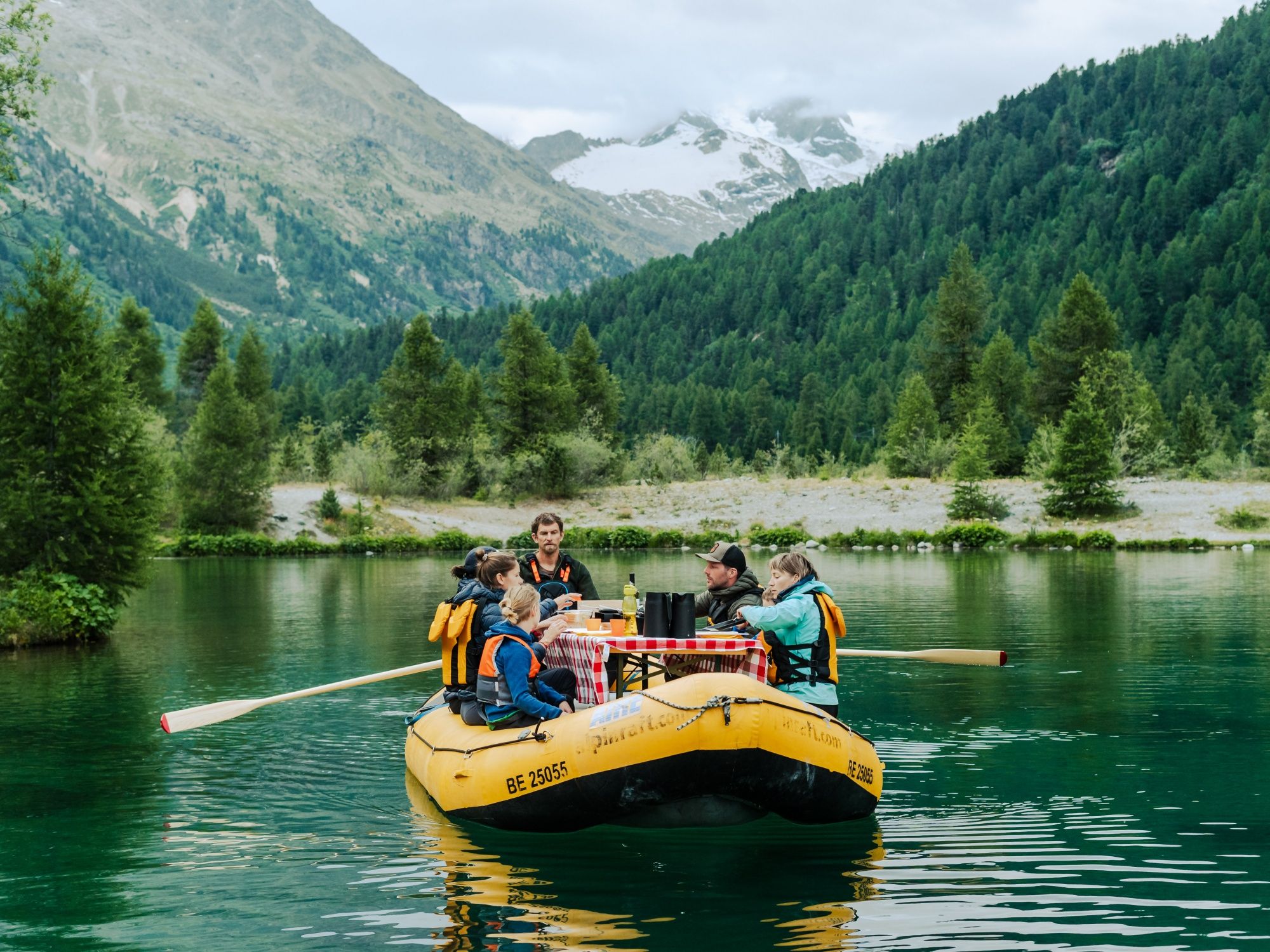 Raclette on the lake with friends in a boat. Summer, nature, and leisure by the water.