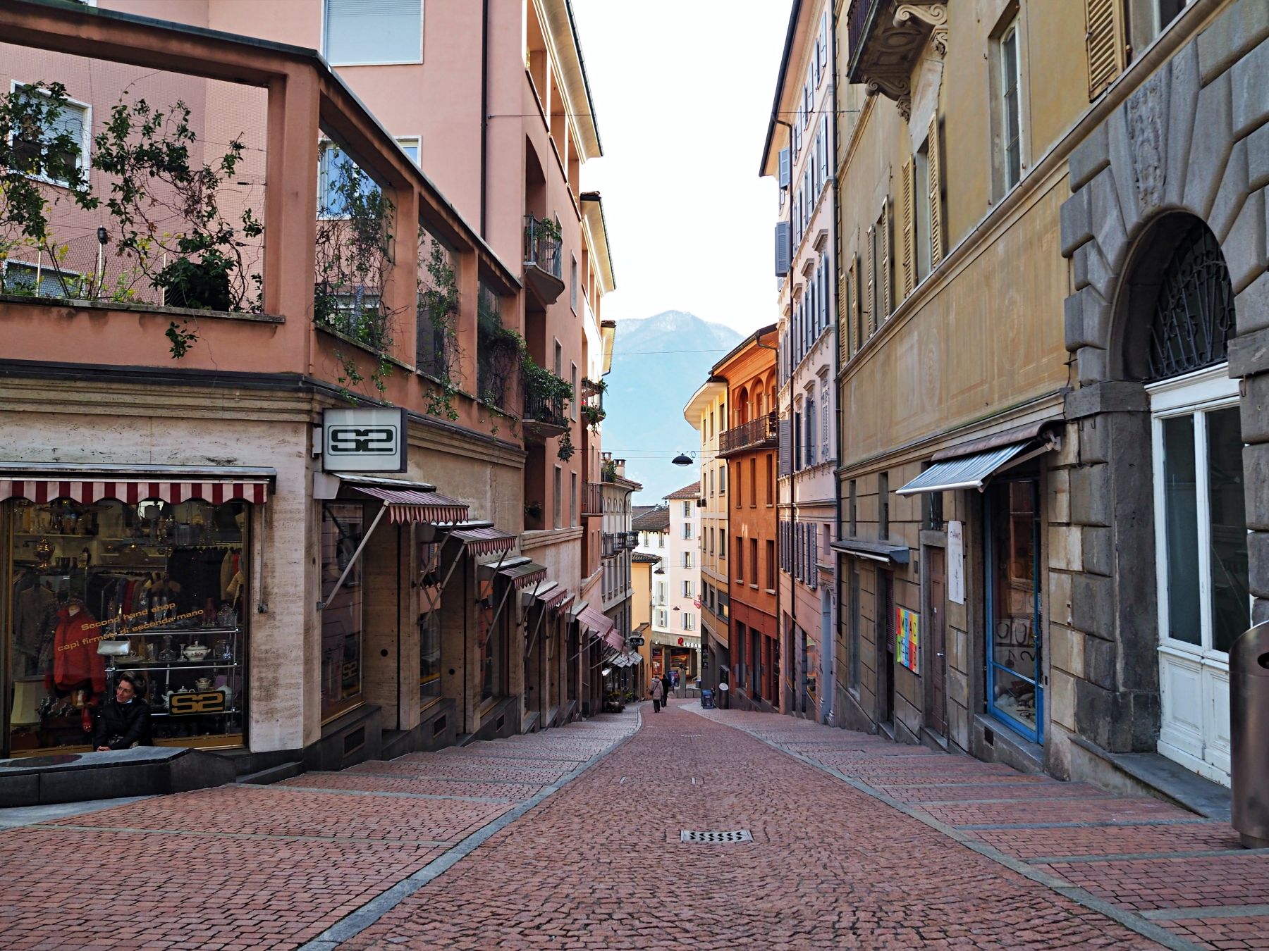 شارع لوجانو مع المباني والمتاجر والمسار، ربيع 2023.
