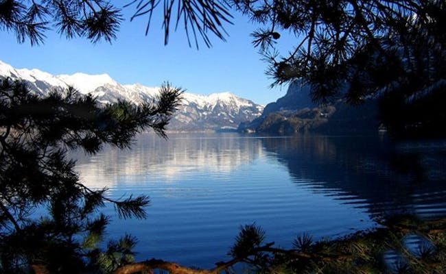 Brienzersee com montanhas cobertas de neve, céu limpo e superfície da água tranquila