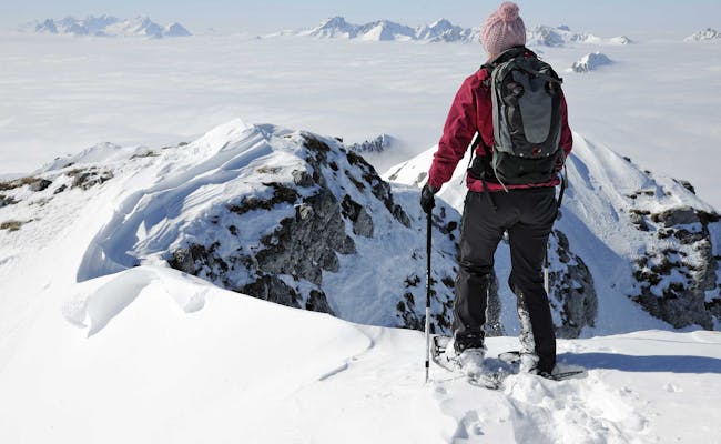 Snowshoe hiking at Stockhorn in winter with snow-covered mountains.