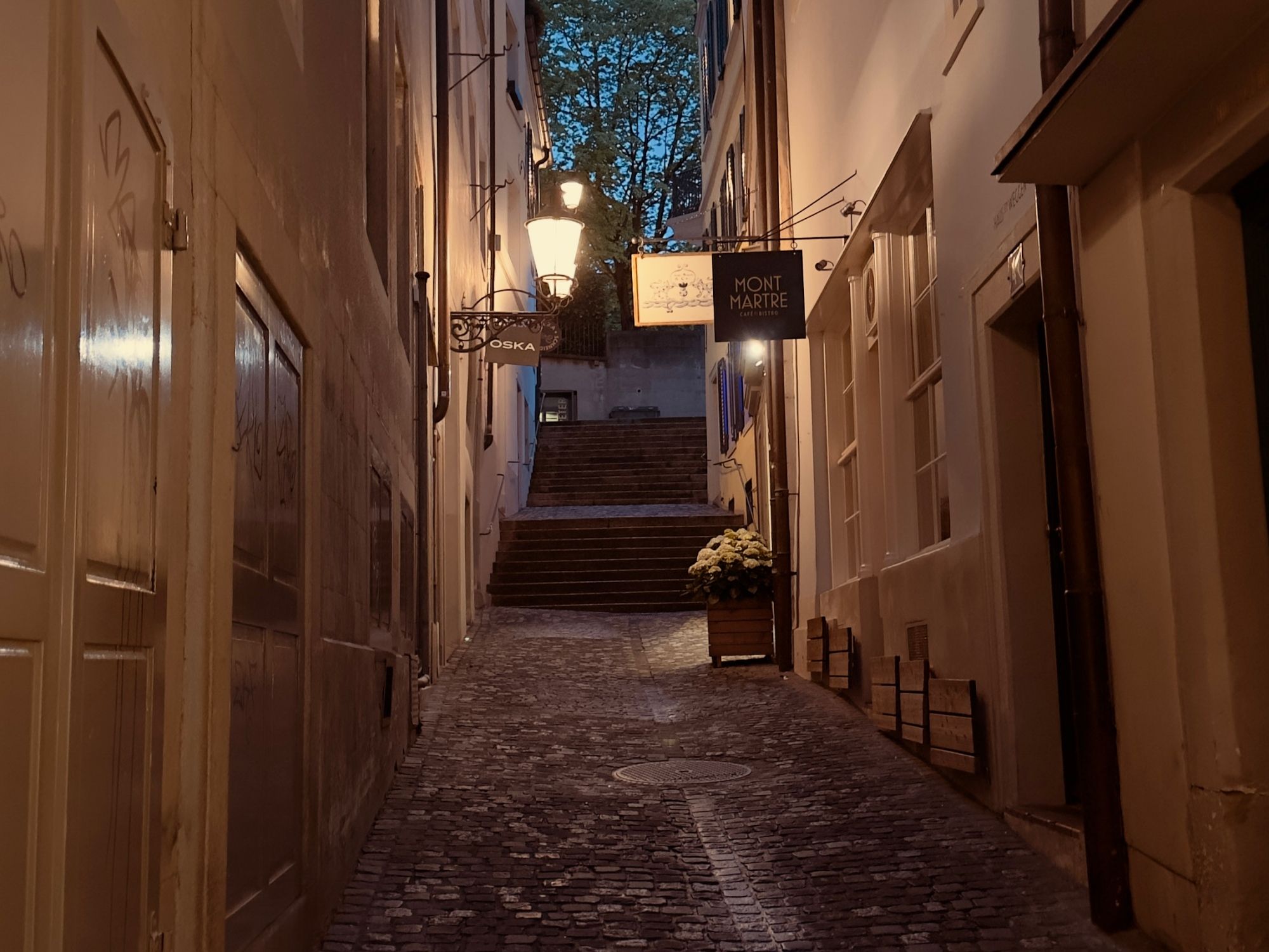 스위스의 구불구불한 골목에서 따뜻한 빛과 역사적인 건물이 있는 야경 촬영.