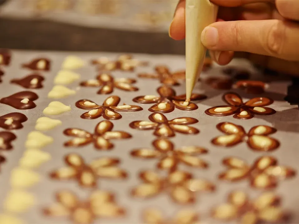 Blomster lavet af chokolade bliver pyntet hos Aeschbach Chocolatier.