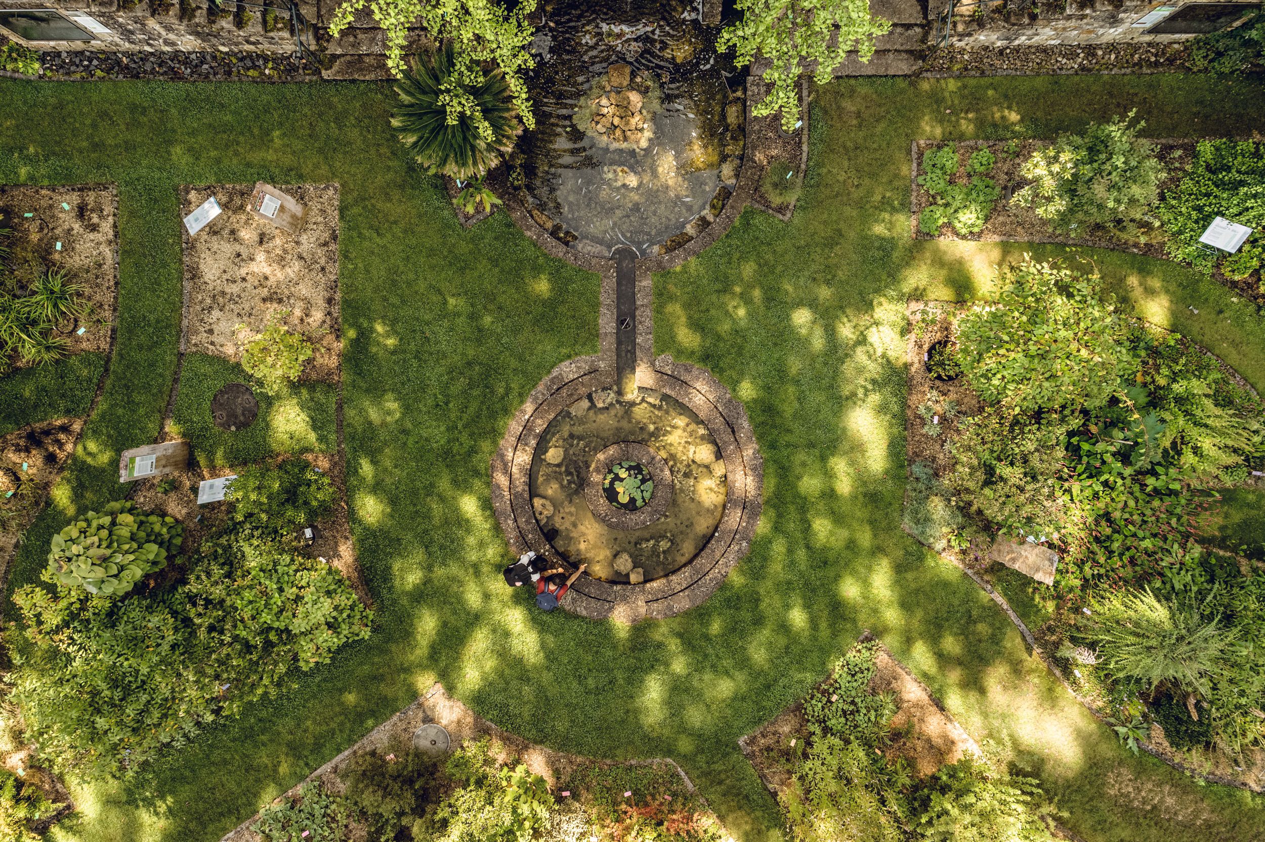 Botanická zahrada s upravenými záhony a fontánou