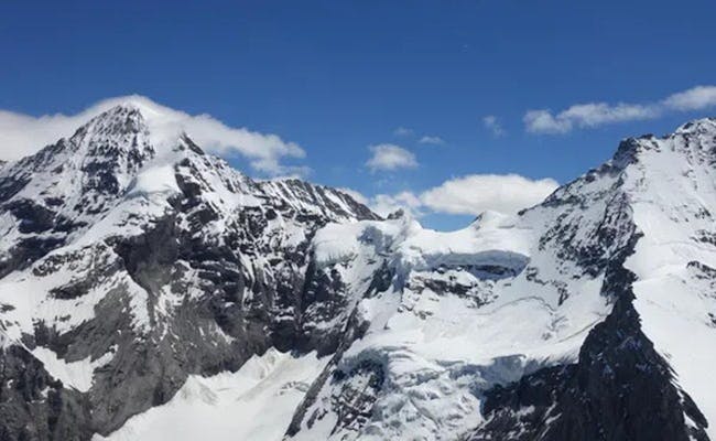 Jungfraujoch helikoptertur med udsigt over snedækkede bjerge.