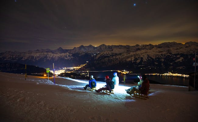 Niederhorn Sternenschlitteln bei Nacht, Rodeln im Schnee, Jungfraumassiv im Hintergrund