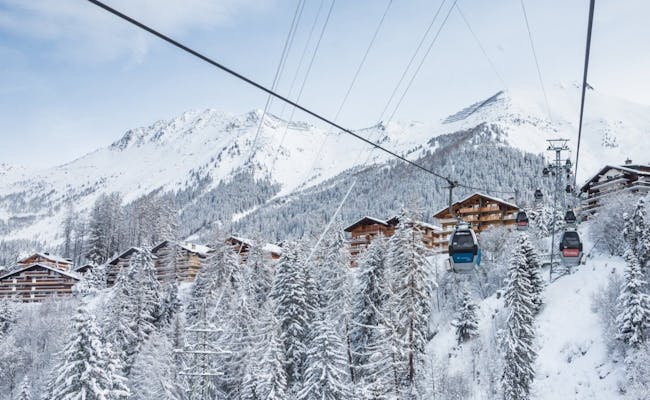 Gondelbahn in Verbier mit Blick auf schneebedeckte Berge und Chalets.
