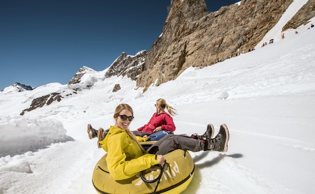 Jungfraujoch Snow Fun Park: Besucher fahren mit Reifen den Schnee hinunter.