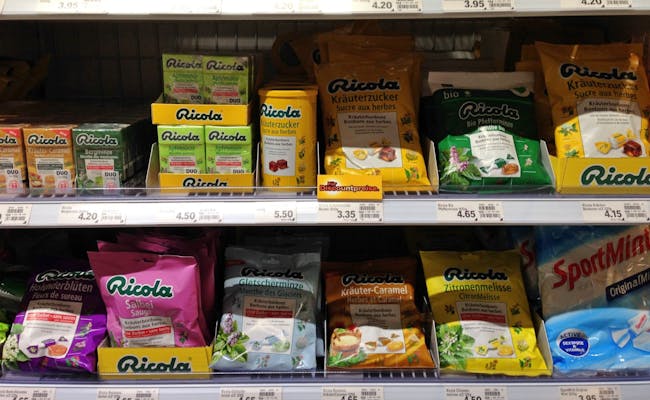 Des bonbons Ricola pour la gorge dans différentes saveurs sur une étagère dans un supermarché.