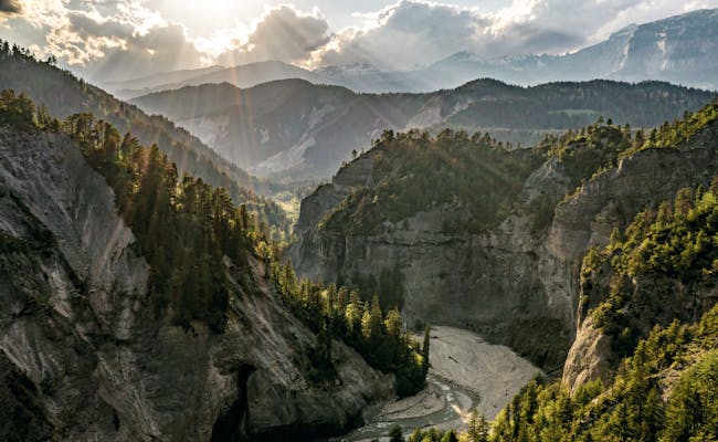 Desfiladero del Rin con sol, montañas boscosas y río