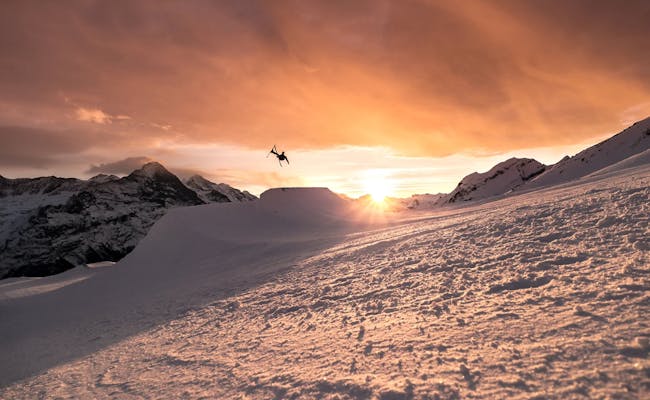 Grindelwald First Snowpark Abendrot: Paisagem de inverno com esquiador ao pôr do sol, experiência inesquecível.
