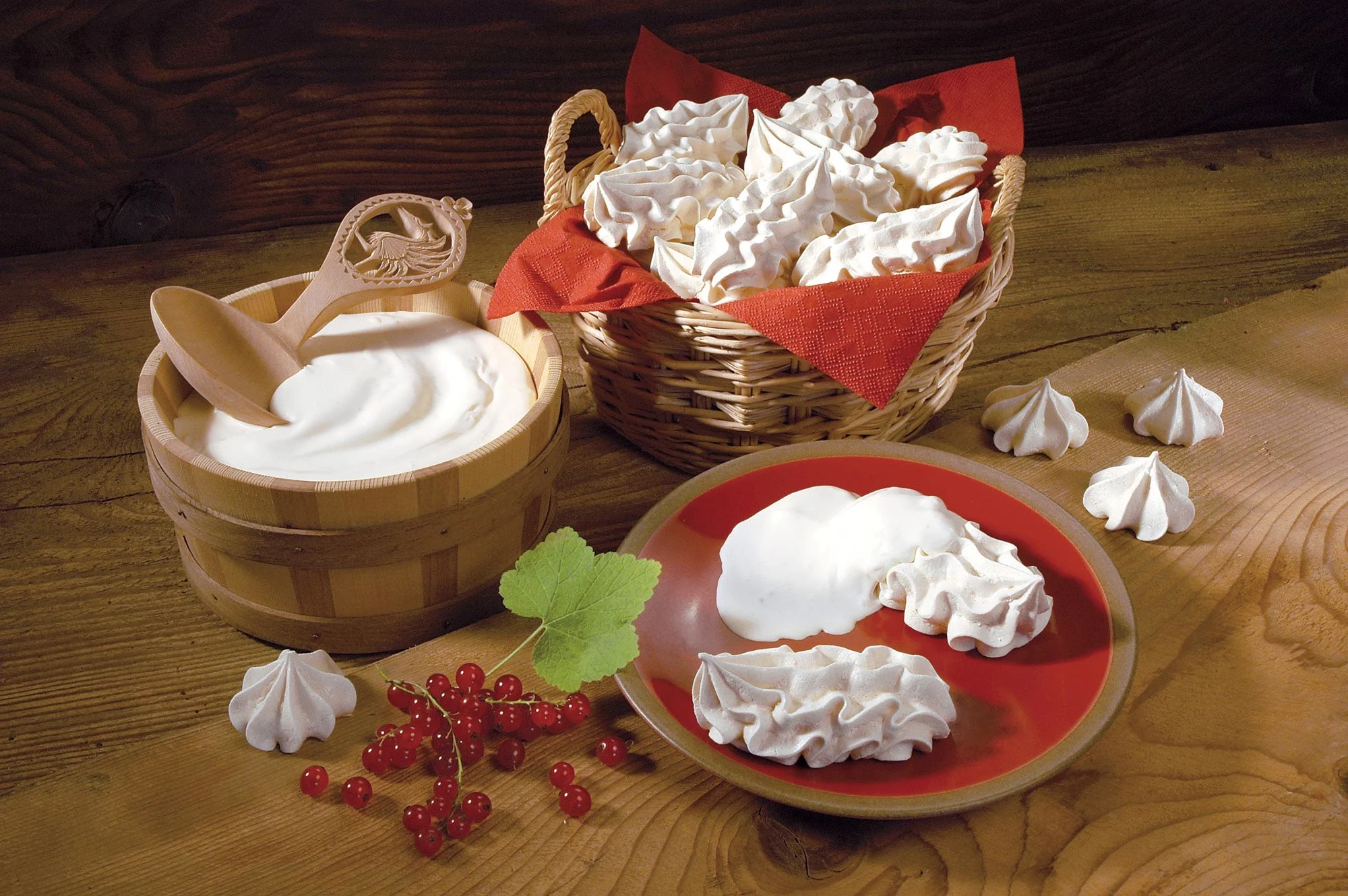 Merengue s šlehačkou a červeným rybízkem na dřevě