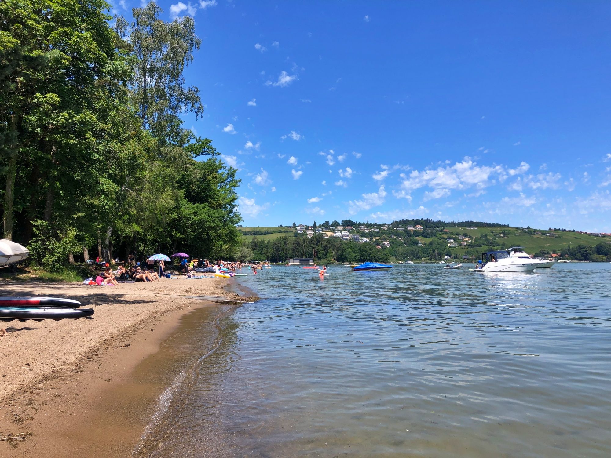 Spiaggia a Salavaux con persone e barche sul lago di Murten.