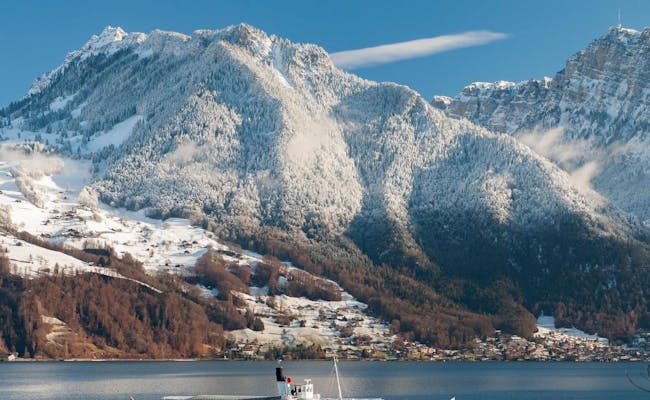 Navegación en el lago de Thun en invierno con montañas cubiertas de nieve y agua tranquila