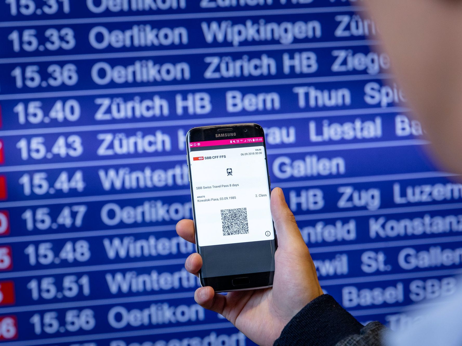 Jadual keberangkatan dengan sambungan kereta di Switzerland, telefon pintar menunjukkan tiket