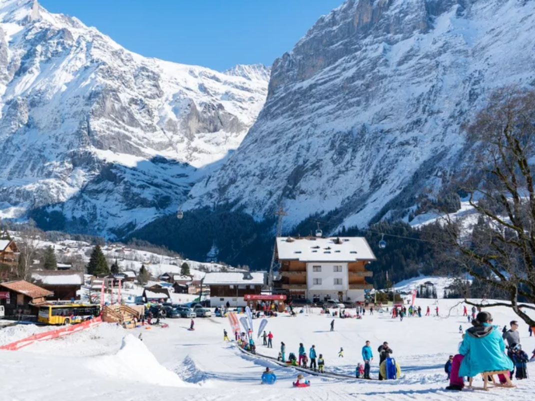 Sledding Bodmi Arena: Winter fun with winter scenery and skiers in the mountains.