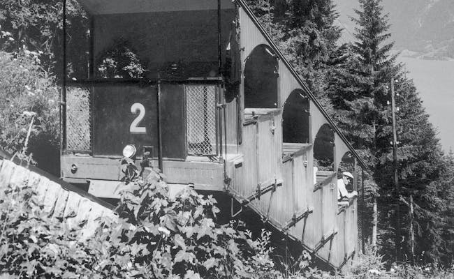 El tren histórico Harder Kulm atraviesa un paisaje forestal.