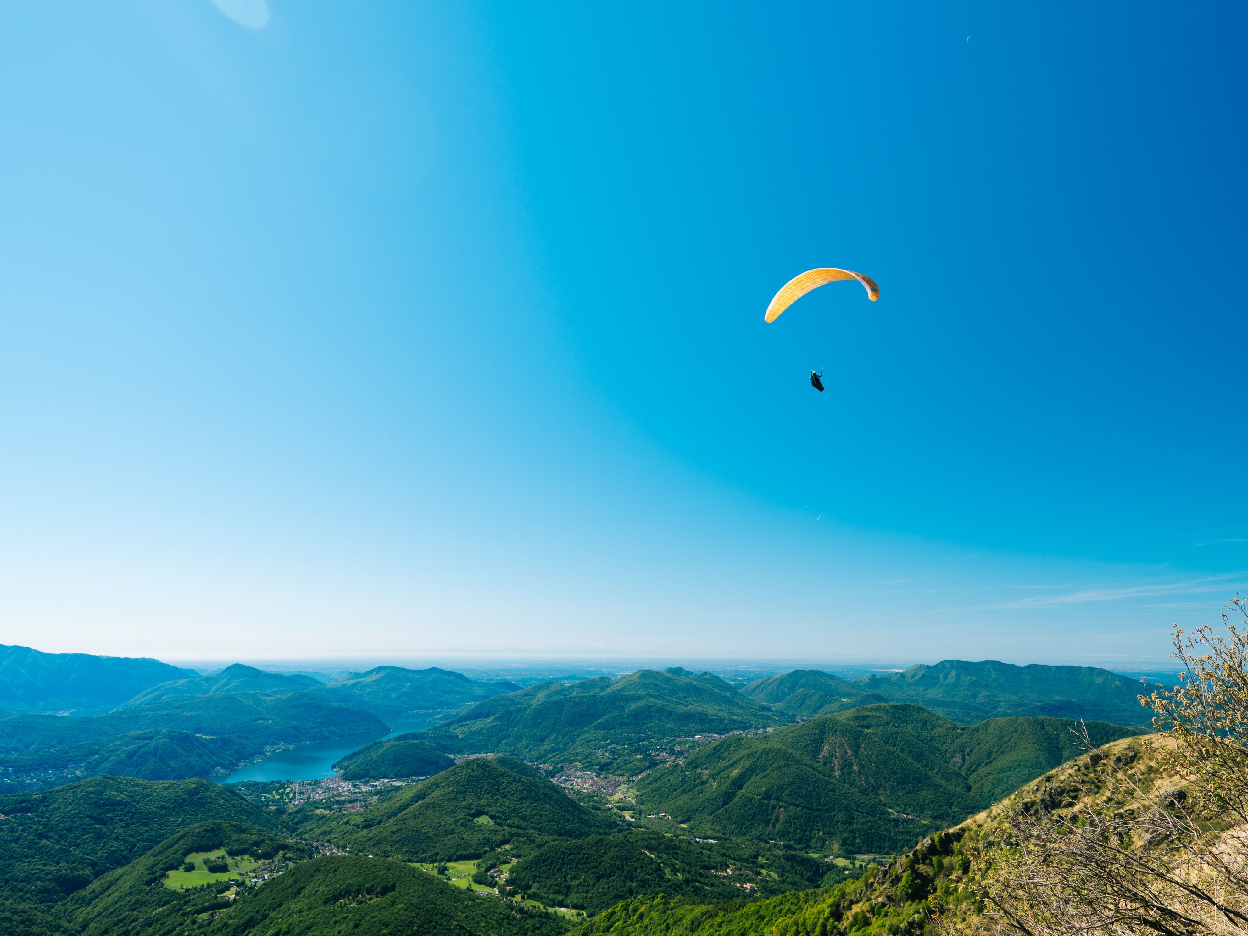 Monte Lema : Parapente au-dessus de paysages pittoresques et de montagnes vertes en été.