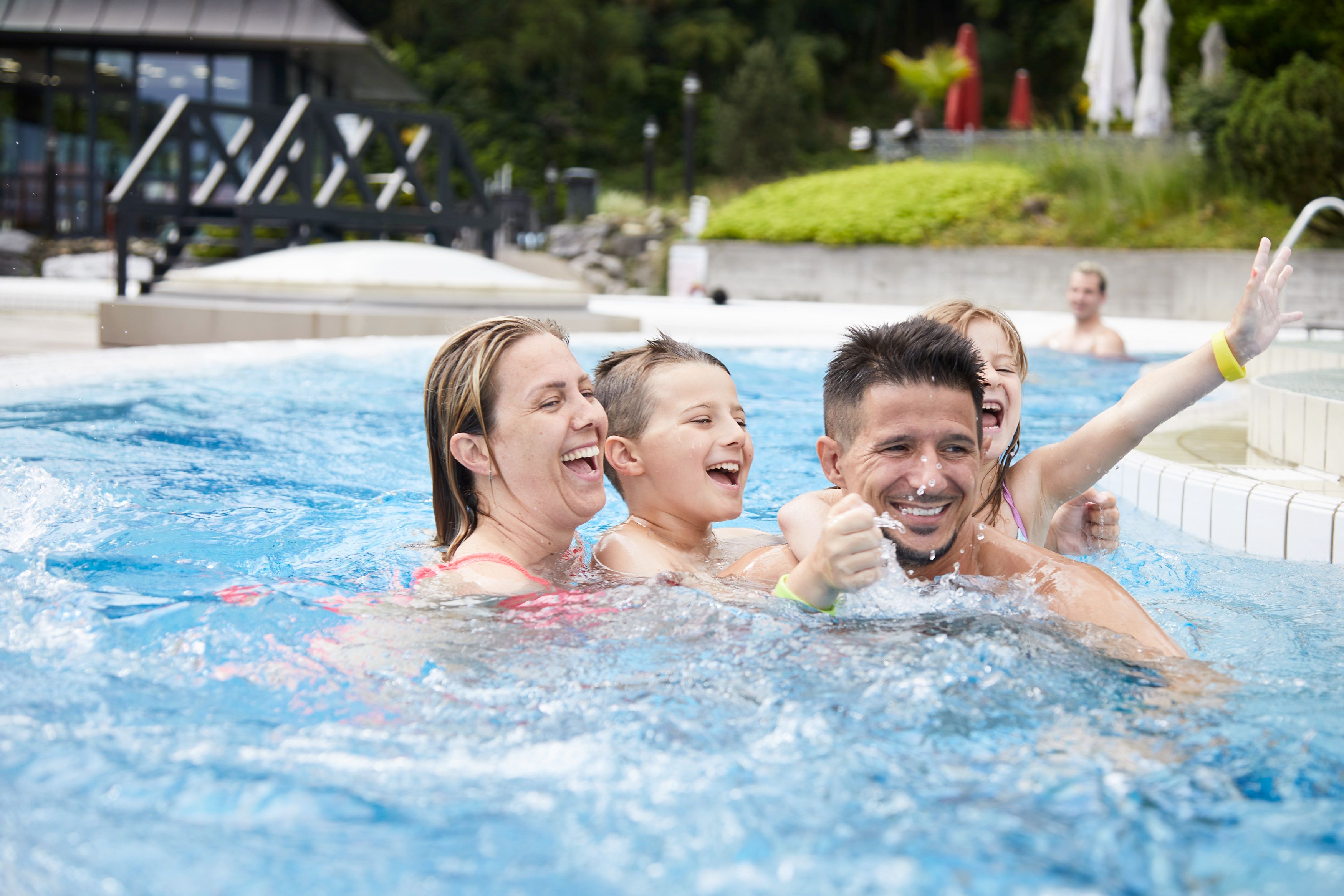 アルパマーレ：家族がプールで夏を楽しみ、水の中で遊んでいます
