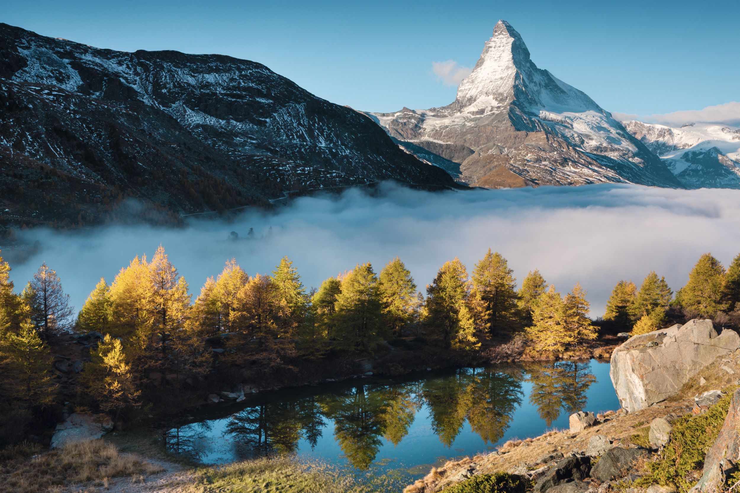 Zermatt : vue sur le Cervin et le lac clair avec des arbres d'automne en toile de fond.