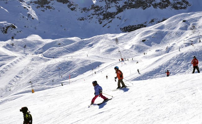 Estación de esquí Airolo Pesciüm con esquiadores en la pista.
