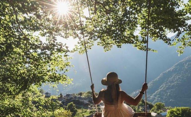 Swing Rasa: geniesse die Aussicht in Tessin auf schaukelnder Bank umgeben von Bergen