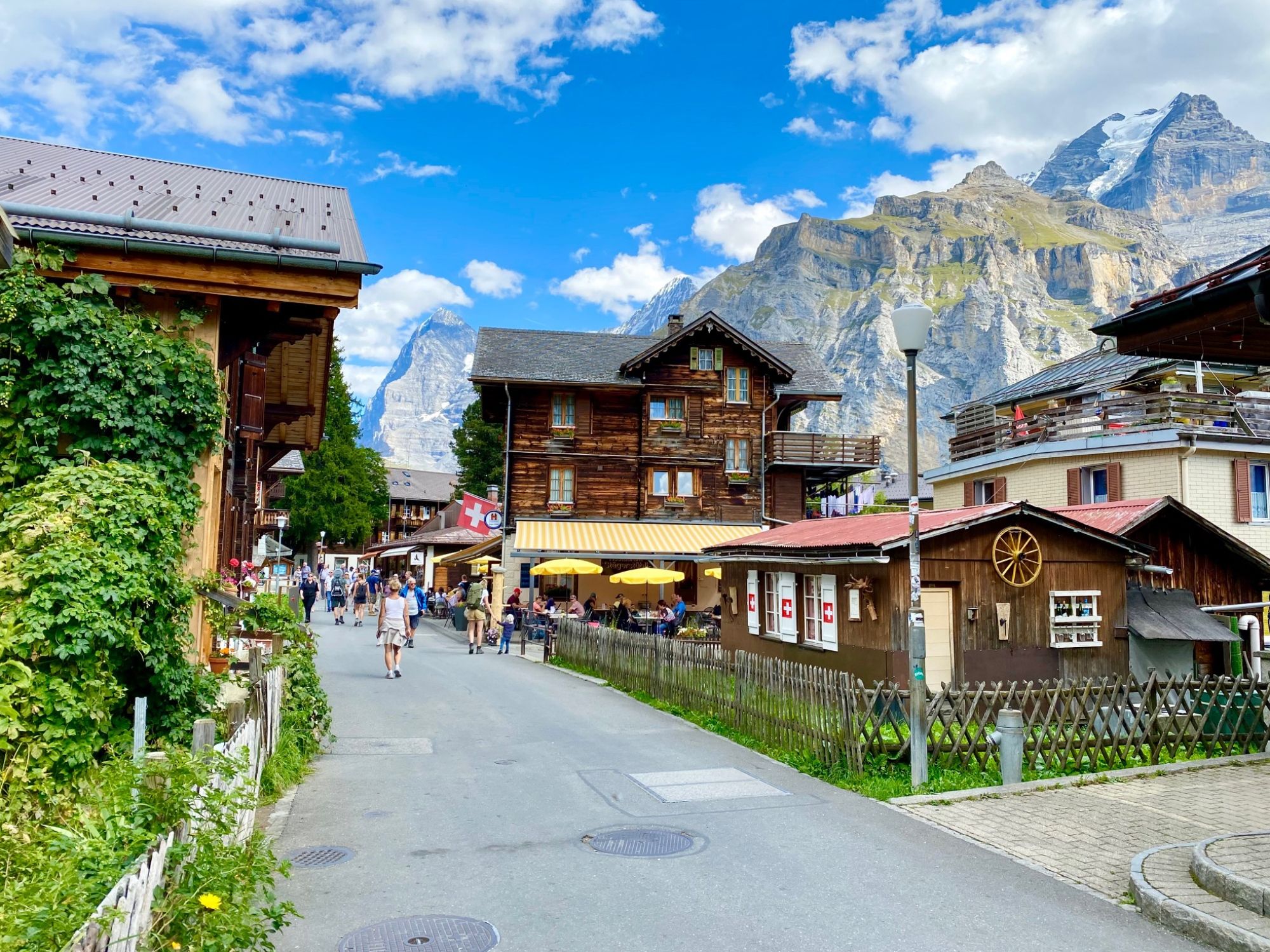 Region Jungfrau: Malebná vesnice s tradiční architekturou a úžasným výhledem na hory v Alpách.