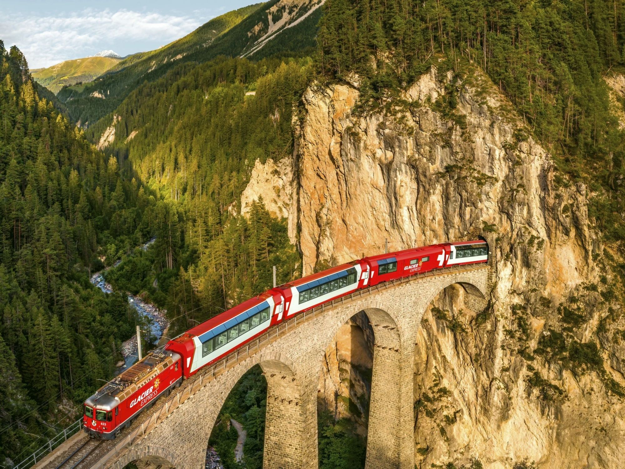 Landwasser Viaduct with red train in the landscape.