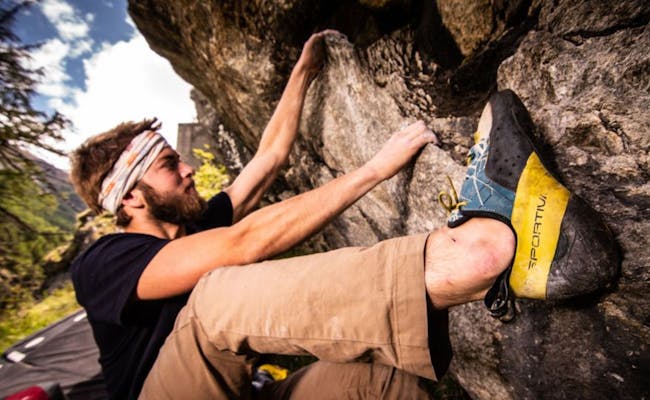 Bouldering Saas-Fee na cestě k kapli s skalami a lezcem.