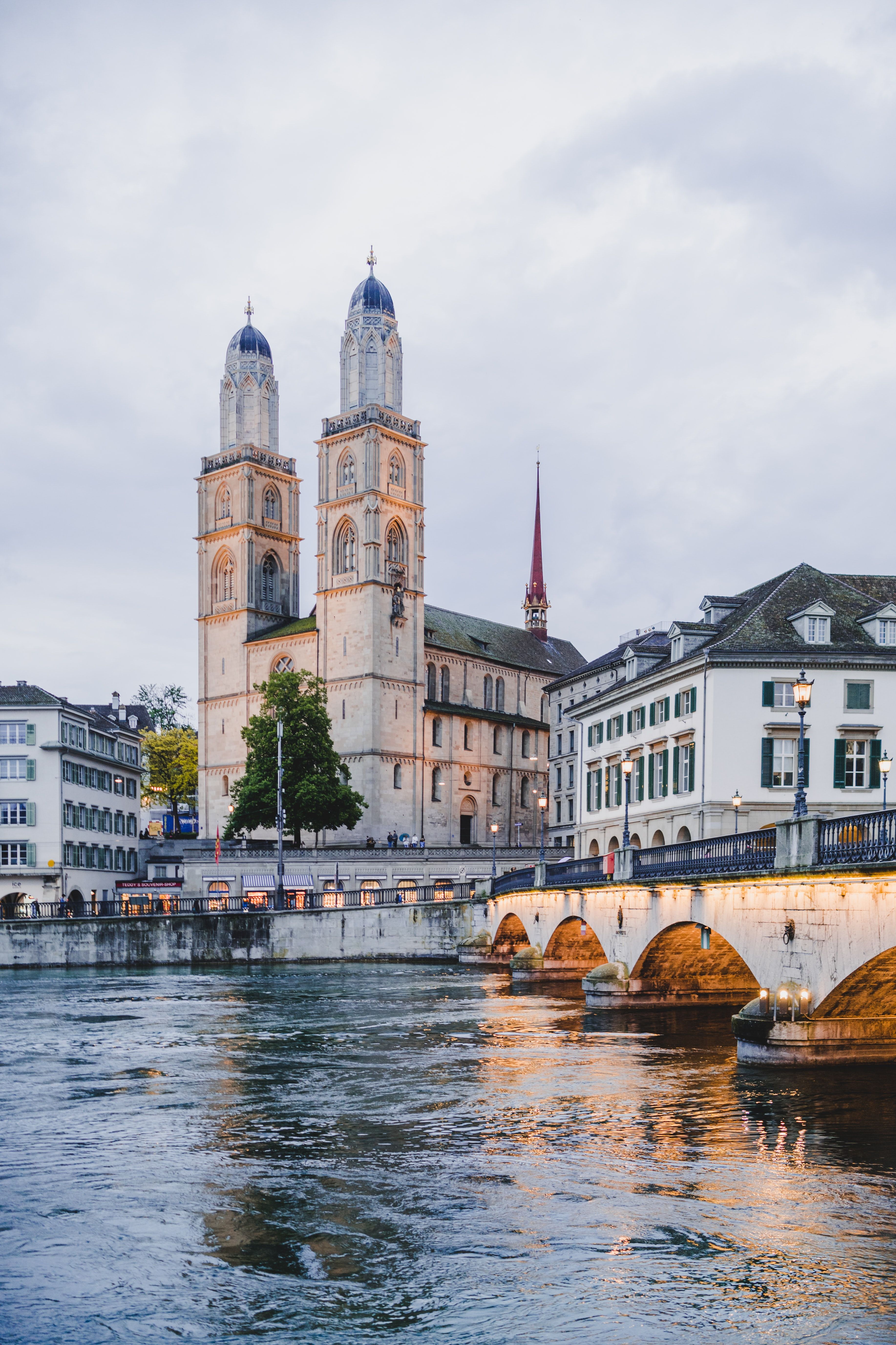 โบสถ์ Grossmünster ในเมืองซูริกระหว่างการท่องเที่ยว มีอาคารประวัติศาสตร์และแม่น้ำล้อมรอบอยู่.